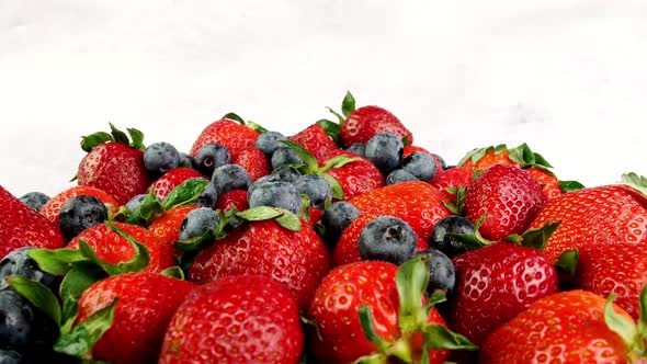 Pile of Summer Juicy Ripe Strawberries and Blueberries Berries Rotate Slowly on Turntable alt