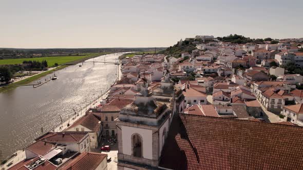Beautiful rooftops of Alcacer Do Sal town on Sado river coastline, aerial orbit view alt