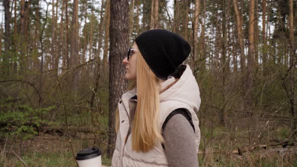 Beautiful Woman Walk in the Forest and Drink Coffee.  High Quality