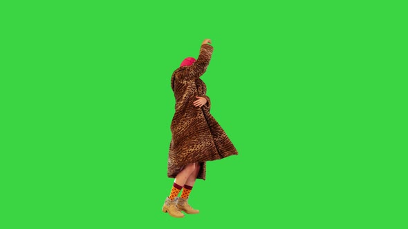 Active Girl in Pink Balaclava Performs Energetic Dance on a Green Screen Chroma Key