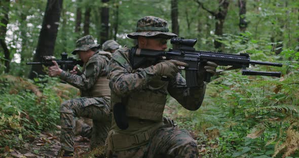 Soldiers in the Smoke Moving in Battle Operation Through Dense Forest alt