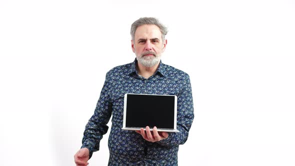 Elderly Man Standing with a Laptop in His Hand Whilst Showing a Thumbs Up alt
