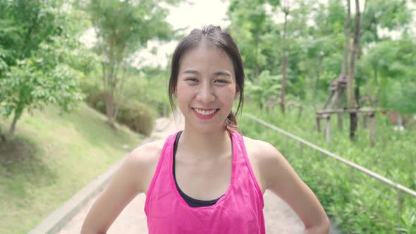 Young Asian woman feeling happy smiling and looking to camera after running on street in urban city
