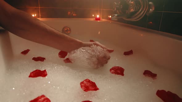 Hand Touches Foam in Bathtub alt