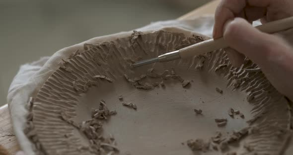 Close Up of Female Pottery Artist at Work Woman Creating Patterns on a Clay Plate Art Work in