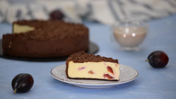 Piece of delicious homemade cheesecake with plums and chocolate crumble.