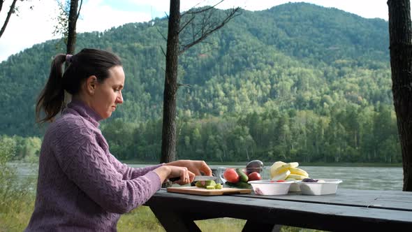 Woman Cutting Vegetables for Salad Outdoors alt