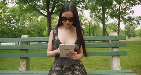 Girl Using A Tablet In The Park b