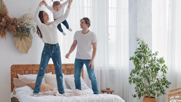 Young Parents Caucasian Couple Playing with Little Daughter Child Girl Mother Strong Woman Lifts alt