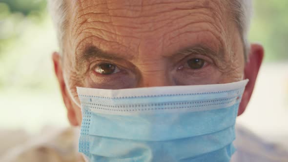 Portrait close up of senior caucasian man wearing face mask and looking at camera in slow motion alt