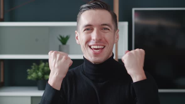 Smiling Young Caucasian Man Showing Win Yes Gesture alt