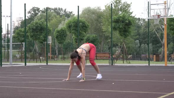 Beautiful Energetic Fitness Girl Doing Jack Burpee Exercises. Doing Workout in a Fenced Outdoor alt