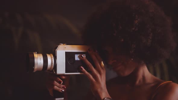 Woman With Afro Hair Using Vintage 8Mm Camera alt