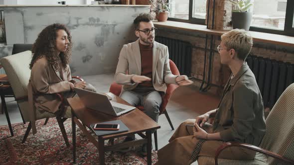 Bearded Businessman Talking to Female Colleagues alt
