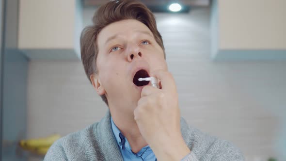 Young Man Using Throat Spray
