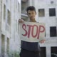 Portrait of Male Emigrant or Refugee Posing with Stop Banner at the Background of Neglected Urban - VideoHive Item for Sale
