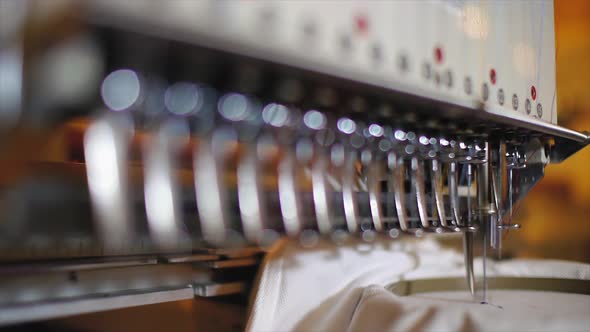 Commercial embroidery machine embroidering logo on a T shirt alt