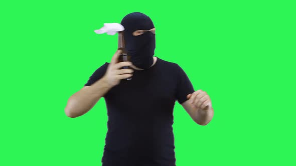 A man in a black mask holds a bottle with a prosperous mixture in his hand