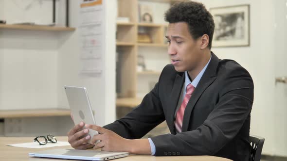 African Businessman Online Video Chat on Tablet alt