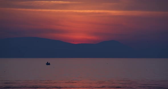 People Silhouettes On Fishing Boat In The Sea At Sunset alt