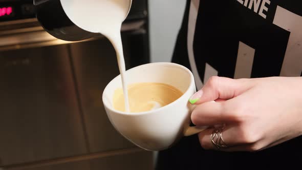 Heated Milk is Poured Into a Cup of Coffee to Make Cappuccino