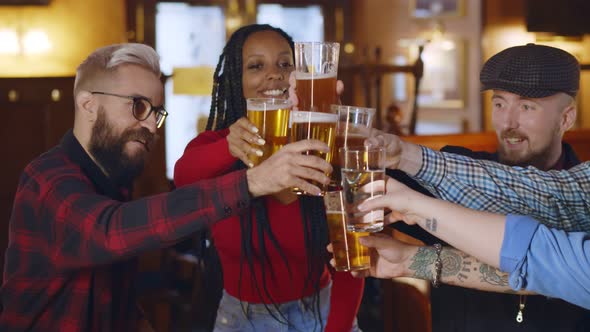 Young Group of Friends Clinking Beer Glasses Having Fun and Celebrating Together alt
