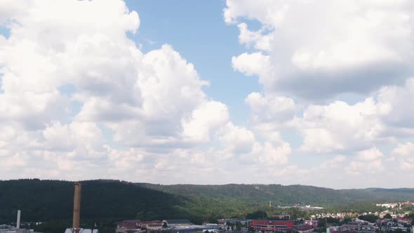 Industrial chimney and living buildings of small town in Sweden, aerial tilt down shot alt