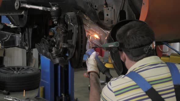 Man Doing Welding Work. Welder Welding A Metal Parts On Vehicle alt