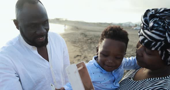 African parents and little son having fun on the beach - Family people and love concept alt