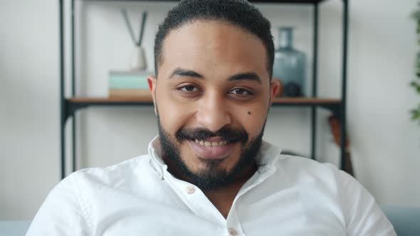 Portrait of Mixed Race Guy Looking at Camera with Serious Face Then Smiling Indoors alt