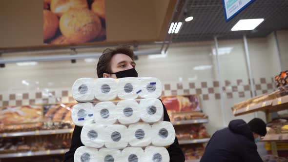 Man Walking in Medical Mask with Toilet Paper Shopping Bags During the Quarantine Coronavirus alt