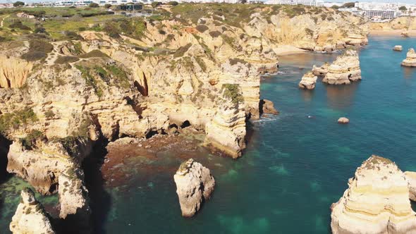 Little beachlets and caves carved into ochre cliffs by the Algarve sea, in Lagos, Portugal alt