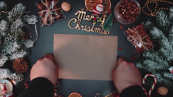 Hands put envelope on New Years table. Concept of New Year and Christmas.