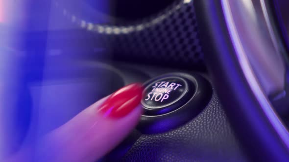 Close Up of Female Finger Pressing an Engine Start Stop Button on Modern Automatic Car