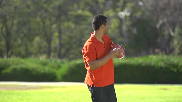 A father teaching his sons how to play American football. alt