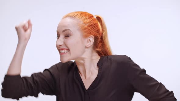 Middleaged Caucasian Woman in Dark Brown Shirt with Colored Orange Hair Actively Rejoicing and alt