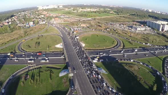 View from air of road interchange with city traffic alt