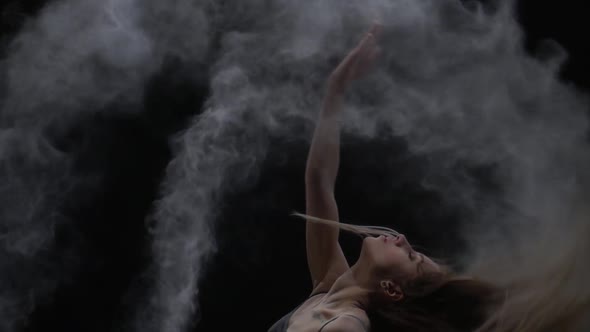 Close-up Slow Motion, Graceful Maiden Throwing Dust Particles in Air on Black Background alt