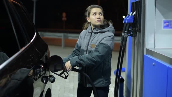 girl completed refueling her car with diesel and closes the gas tank alt