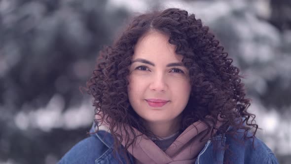 Happy Young Woman with Afro Curls in a Winter City