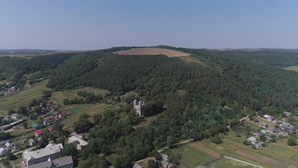 Aerial of a village near a hill alt
