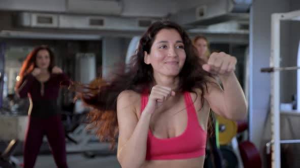 Young Beautiful Smiling Female Athletes Doing Boxing Warm-up in the Gym, Fitness Training Workout