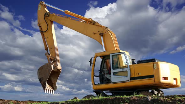 Excavator machinery against the moving clouds 