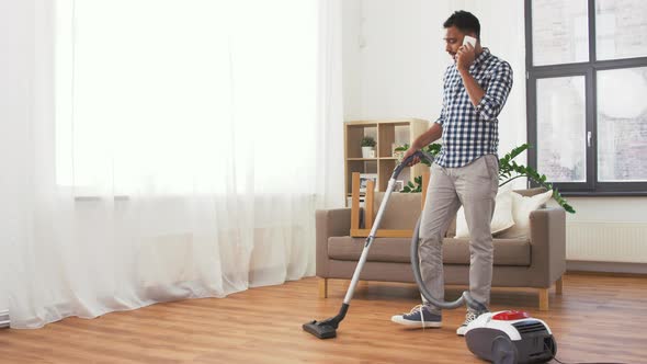 Man with Vacuum Cleaner Calling on Cell at Home 118 alt