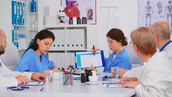 Team of Doctors Sitting in Conference Hospital Office Room Discussing alt