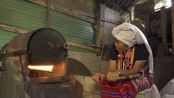 A karen tribe woman roasting coffee beans by using traditional local coffee alt