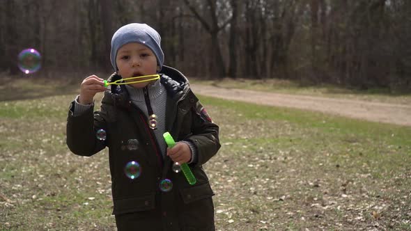 Little Boy Make a Soap Bubbles in Park Slow-mo