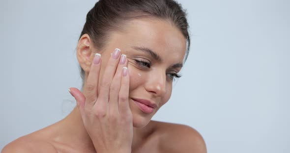Beautiful Woman with Touching Natural Healthy Skin Using Facial Moisturizer Applying Face Cream alt