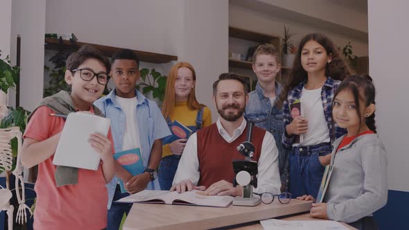 Male Teacher with Elementary School Children Looking at Camera and Smiling alt