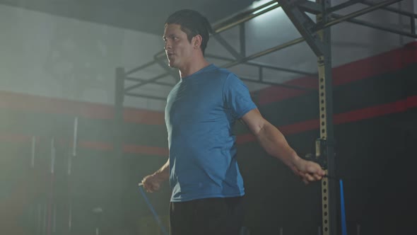 Caucasian young athlete or sport man working out exercise using jumping rope in gym or fitness. alt